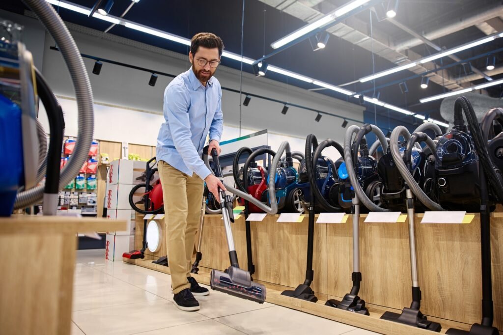 A man is currently engaged in shopping for a vacuum cleaner at a local appliance store