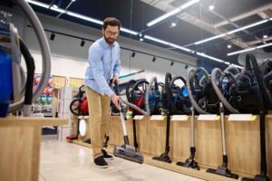 A man is currently engaged in shopping for a vacuum cleaner at a local appliance store